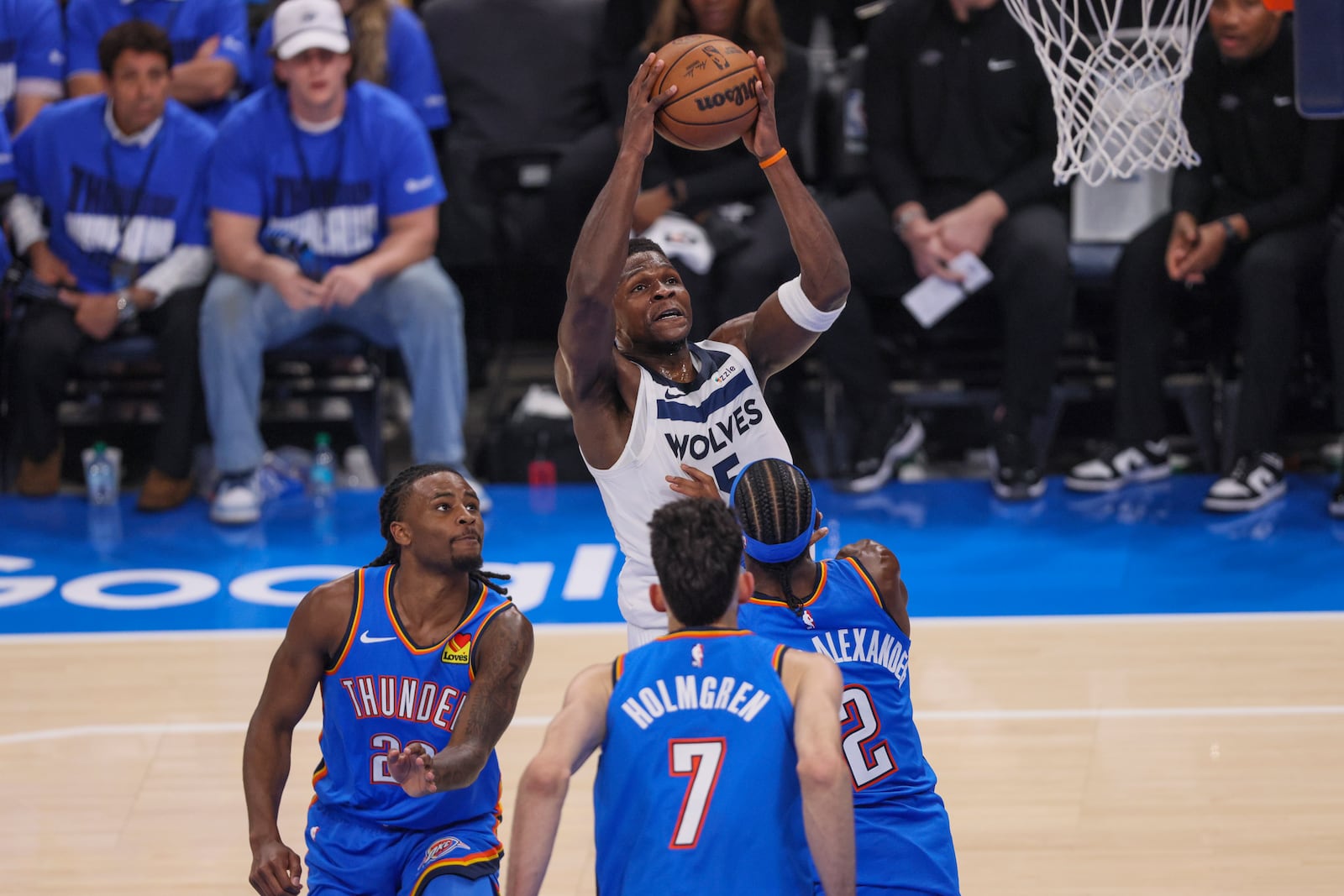 Minnesota Timberwolves guard Anthony Edwards, top, goes up for a basket agains Oklahoma City Thunder guard Cason Wallace (22), forward Chet Holmgren (7) and guard Shai Gilgeous-Alexander (2) during the first half of Game 2 of an NBA basketball Western Conference Finals playoff series Thursday, May 22, 2025, in Oklahoma City. (AP Photo/Nate Billings)