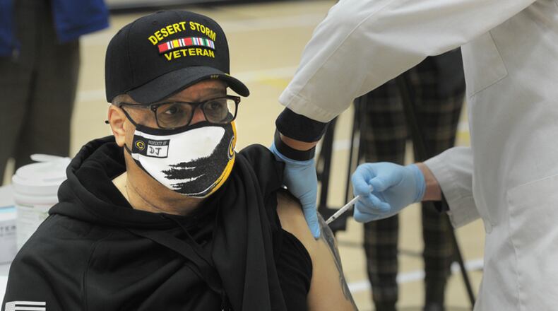 DJ Johnson, Centerville schools security officer, receives his first dose of COVID-19 vaccine at Centerville High School, Wednesday, Feb. 3, 2021.