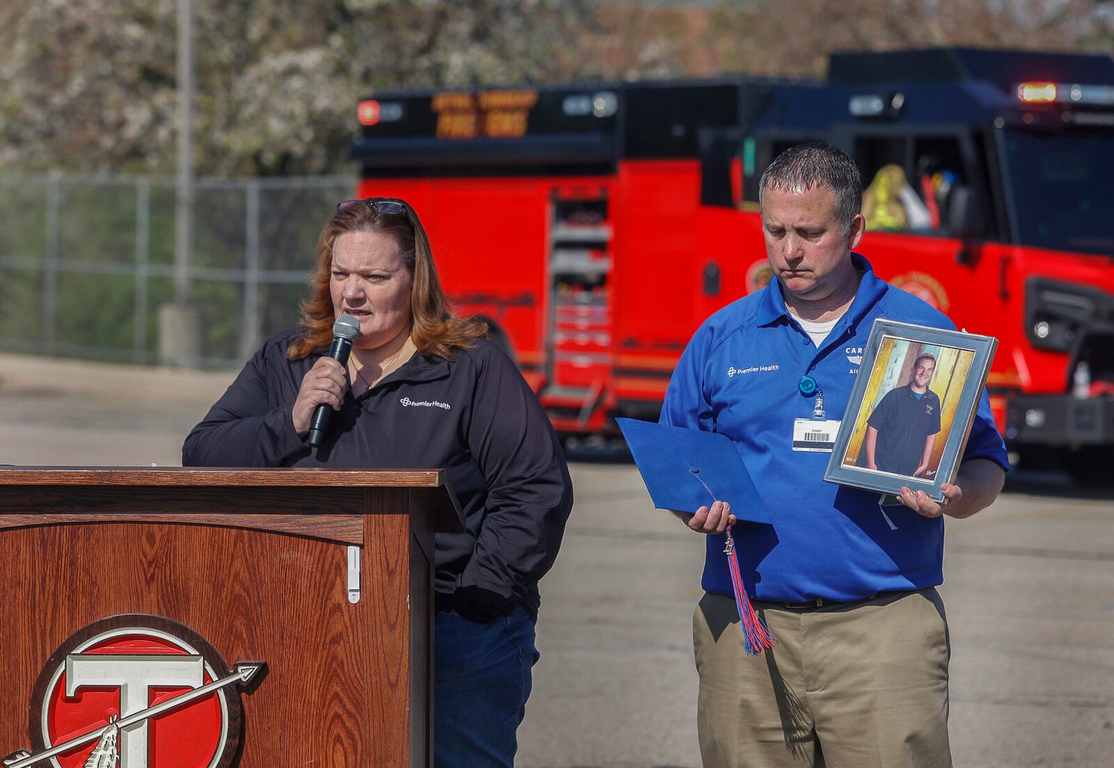 Laura Seger, left, of Pleasant Hill, talks about her son, Joey, who was killed at 18 by a driver under the influence to warn teenagers about the dangers of impaired driving next to Michael Moyer, left, flight nurse of Careflight Air & Mobile, during a mock crash simulation on Wednesday, April 23, 2025, at Tecumseh High School. JOSEPH COOKE/STAFF
