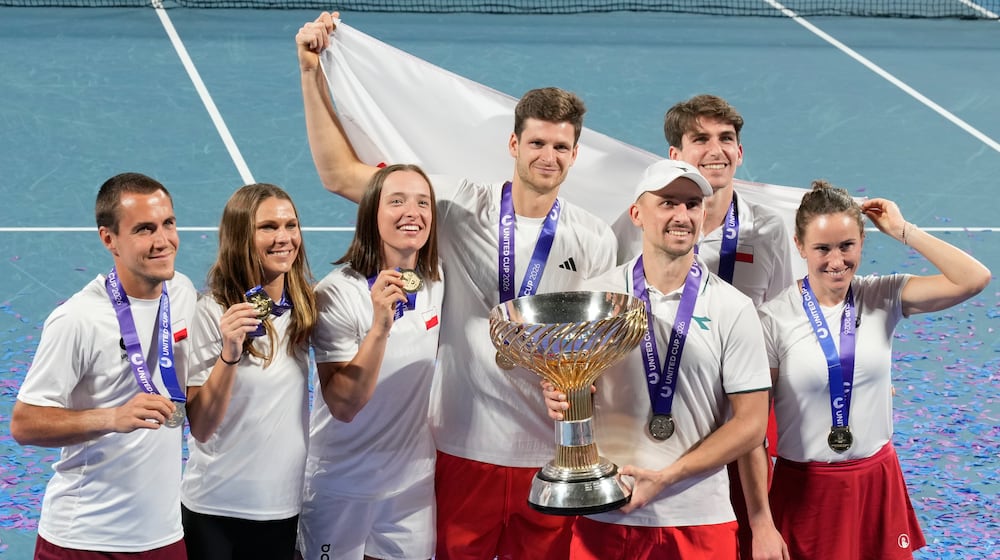 Teammembers from Poland celebrate with their trophy after defeating Switzerland in the final at the United Cup tennis tournament in Sydney, Monday, Jan. 12, 2026. (AP Photo/Rick Rycroft)