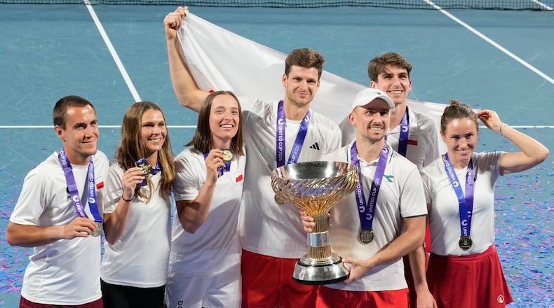 Teammembers from Poland celebrate with their trophy after defeating Switzerland in the final at the United Cup tennis tournament in Sydney, Monday, Jan. 12, 2026. (AP Photo/Rick Rycroft)