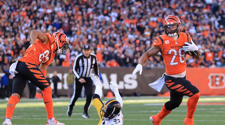Cincinnati Bengals running back Joe Mixon (28) evades Pittsburgh Steelers cornerback Arthur Maulet (35) to score a touchdown during the first half of an NFL football game, Sunday, Nov. 28, 2021, in Cincinnati. (AP Photo/Aaron Doster)