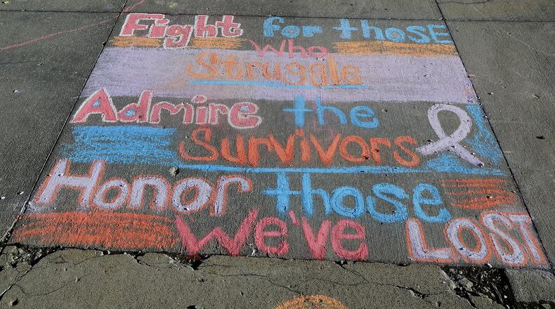 In this file photos, members of the Clark County community draw pictures and write messages to their loved ones on the Springfield City Hall Plaza Wednesday, August 31, 2022 during the first ever Chalk the Walk to celebrate the memory of those lost to substance overdose and help prevent future overdoses. Chalk the Walk coincided with International Overdose Awareness Day. The event, presented by the Clark County Substance Abuse Coalition in collaboration with Clark County Partners in Prevention, also featured overdose prevention resources including free Narcan kits. BILL LACKEY/STAFF