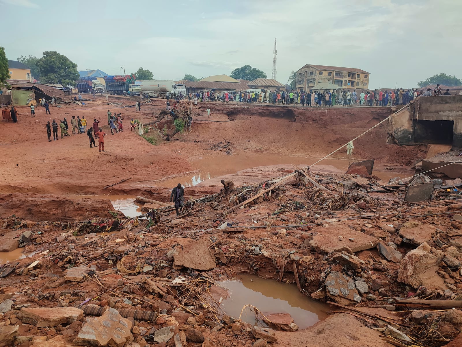 People search in flooded area following a downpour in Mokwa, Nigeria, Friday, May 30, 2025. (AP Photo/Chenemi Bamaiyi)