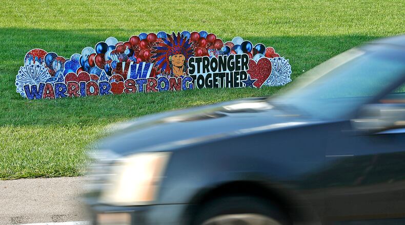 A memorial has started to form Wednesday, August 23, 2023 along Troy Road at the site of Tuesday's fatal bus crash. BILL LACKEY/STAFF