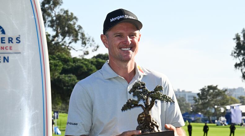 Justin Rose, of England, holds the winner's trophy at the Farmers Insurance Open golf tournament Sunday, Feb. 1, 2026, at Torrey Pines in San Diego. (AP Photo/Denis Poroy)