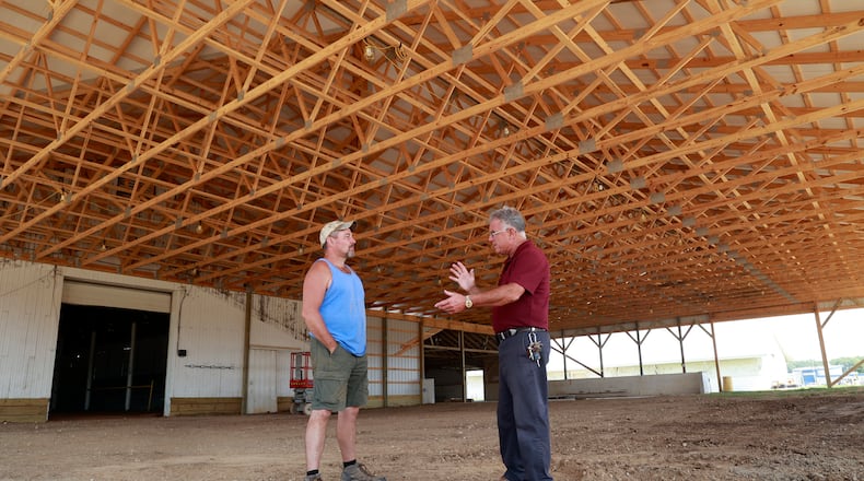 Dean Blair, executive director of the Clark County Fairgrounds talks with Robert Haffner, the maintenance manager at the fairgrounds, as they stand in the new addition that has been added to the Cattle Barn Arena Tuesday, July 11, 2023. BILL LACKEY/STAFF