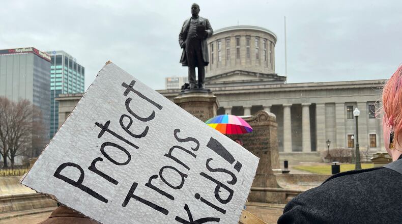 Protesters advocating for transgender rights and healthcare stand outside of the Ohio Statehouse on Wednesday, Jan. 24, 2024, in Columbus, Ohio. The Republican-dominated Ohio state Senate voted Wednesday to override GOP Gov. Mike DeWine's veto of a gender-affirming care ban for minors and a ban that restricts transgender athletes' participation in girls and women's sports. (AP Photo/Patrick Orsagos)