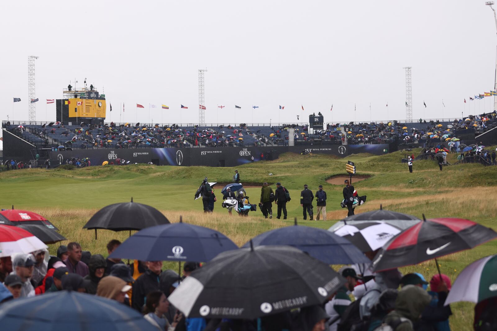 A general view of the 18th green as a group of players including Lee Westwood of England walk to the green during the first round of the British Open golf championship at the Royal Portrush Golf Club, Northern Ireland, Thursday, July 17, 2025. (AP Photo/Peter Morrison)