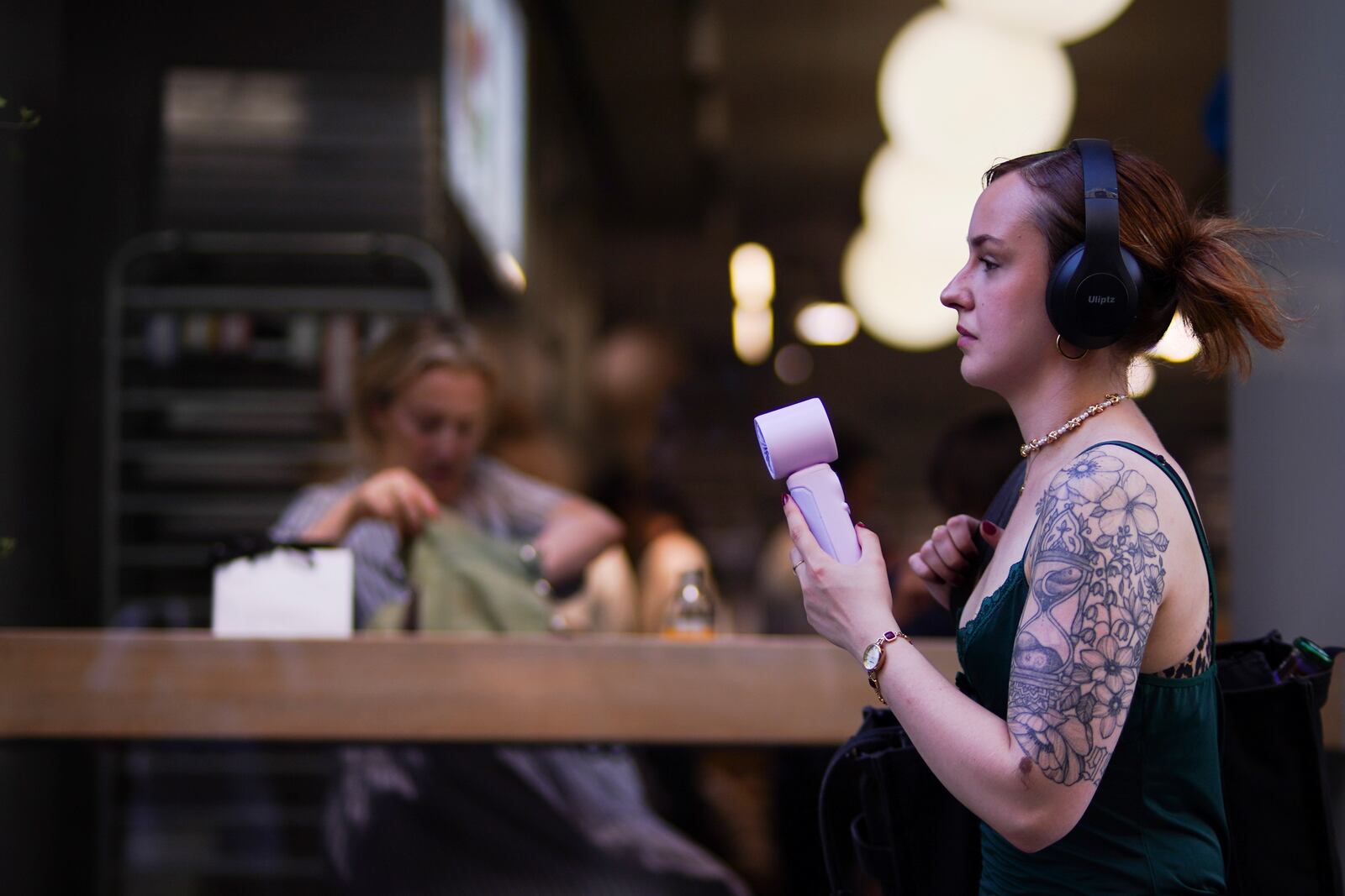 A woman uses a handheld fan in hot weather in Covent Garden, in London, Monday, June 30, 2025. (AP Photo/Alberto Pezzali)