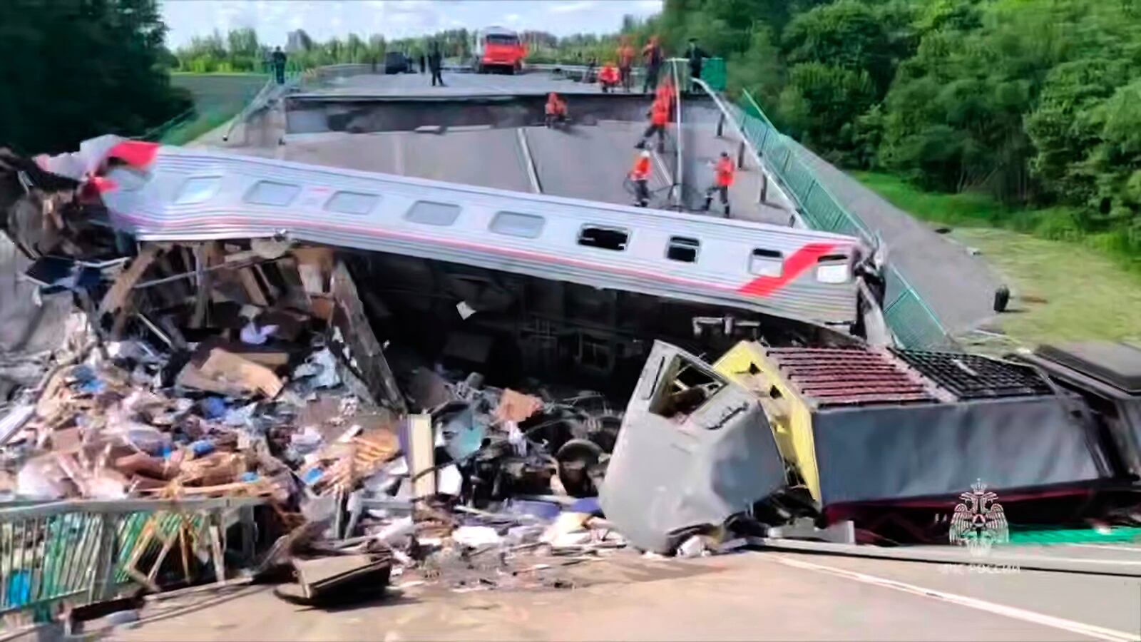 In this photo released by Russian Emergency Ministry Press Service telegram channel on Sunday, June 1, 2025, emergency employees work at a damaged bridge in Russia's Bryansk region, which borders Ukraine. (Russian Emergency Ministry Press Service telegram channel via AP)