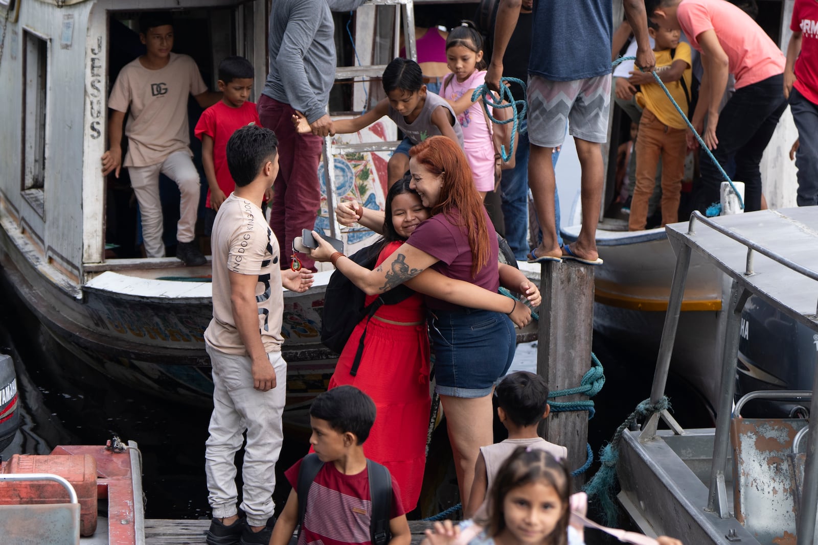 A girl embraces biologist Tatyanna Mariúcha, head of the Emilio Goeldi Museum's scientific base, as children arrive at the station in the Caxiuana National Forest in Para state, Brazil, Friday, March 21, 2025. (AP Photo/Jorge Saenz)