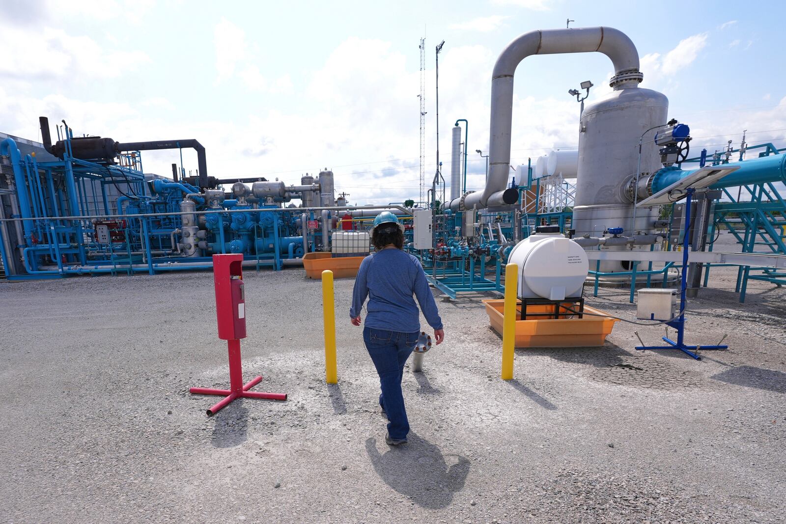 BKV Carbon Ventures senior facility engineer Laura Mamazza walks at a compression station at a carbon capture and sequestration facility in Bridgeport, Texas, Thursday, May 29, 2025. (AP Photo/LM Otero)