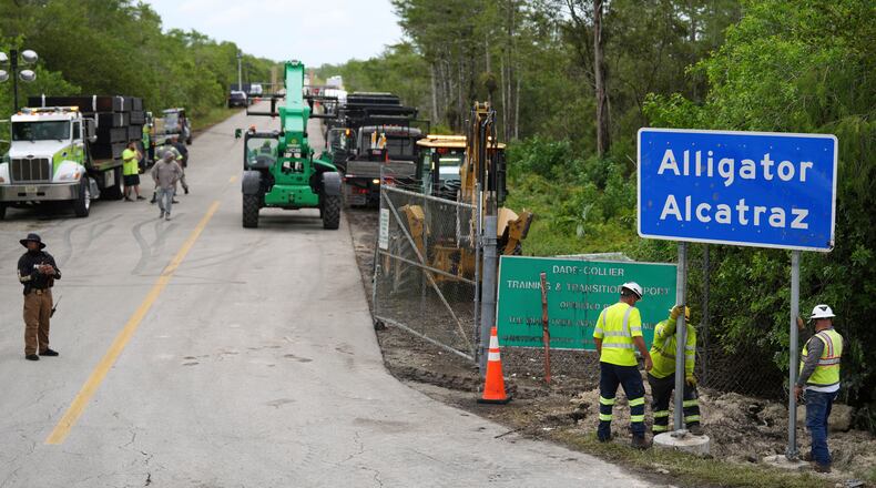 FILE - Workers install a sign reading "Alligator Alcatraz" at the entrance to the migrant detention facility at Dade-Collier Training and Transition facility, July 3, 2025, in Ochopee, Fla. (AP Photo/Rebecca Blackwell, file)