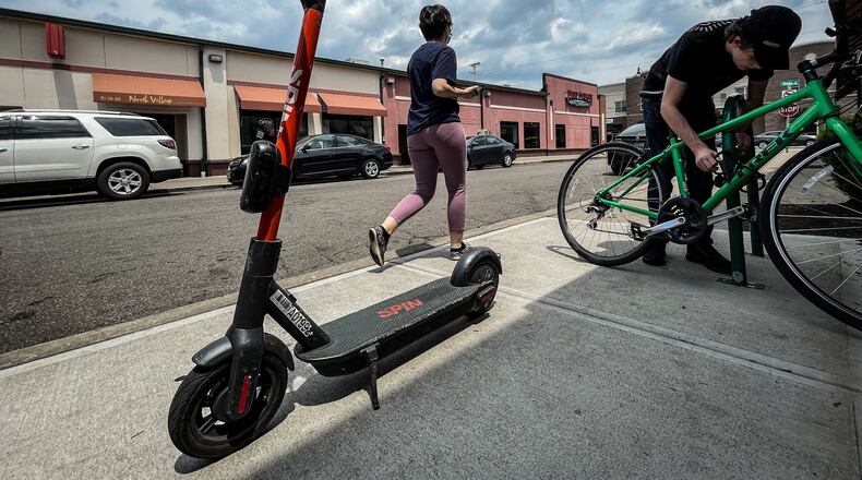 A Spin electric scooter rests outside Panera Bread on Jasper Street in Dayton on Tuesday. The City of Springfield is in talks with a company that wishes to bring those scooters to downtown Springfield. JIM NOELKER/STAFF