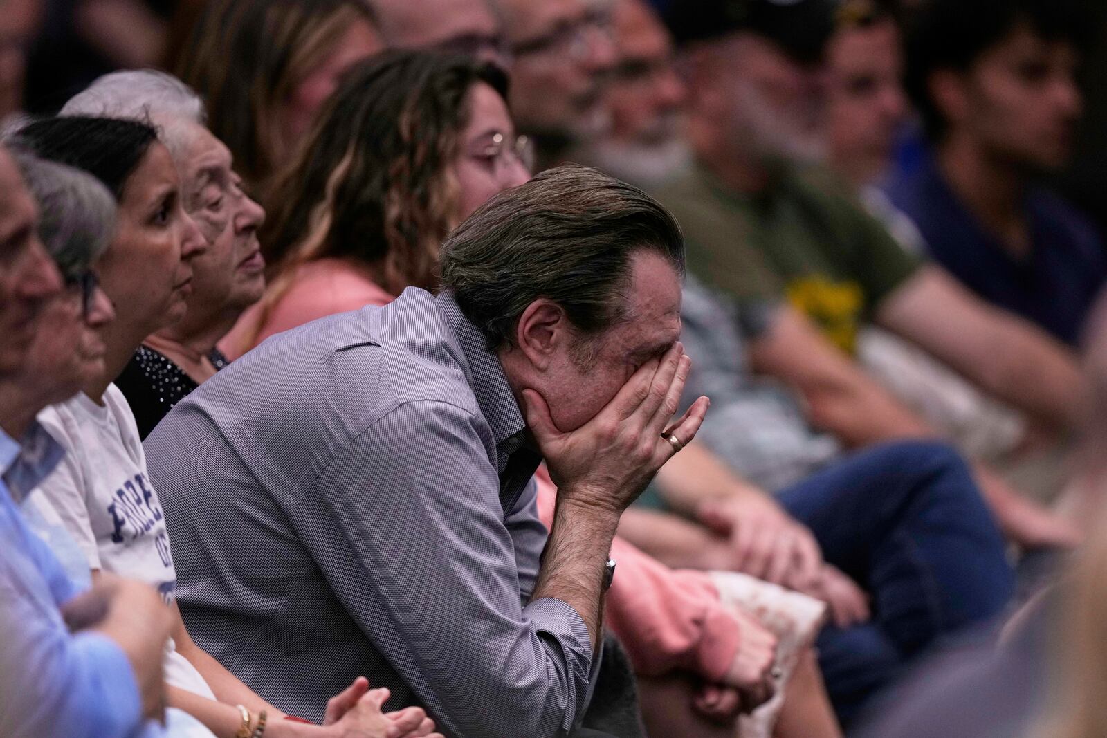 People at the Jewish Community Center of Greater Kansas City mourn Sarah Milgrim and Yaron Lischinsky, Israeli Embassy staff members who were shot and killed while leaving an event at a Jewish museum in Washington, Thursday, May 22, 2025, in Overland Park, Kan. (AP Photo/Charlie Riedel)