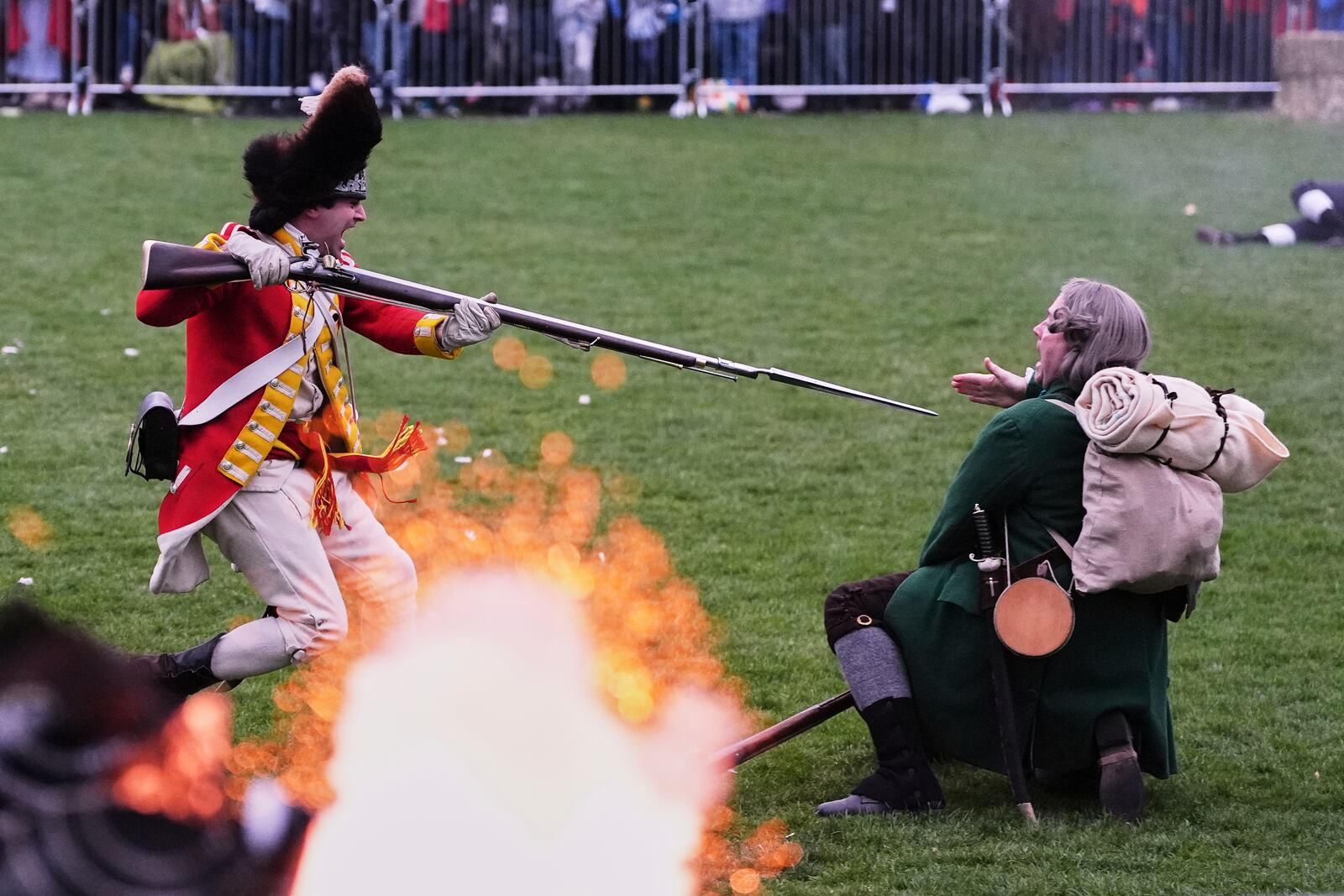 While a rifle fires, a British Regular stabs a New England colonial militia, also known as a Minuteman, during a reenactment celebration of the 250th anniversary of the Battle of Lexington and start of the American Revolution, Saturday, April 19, 2025, in Lexington, Mass. (AP Photo/Charles Krupa)