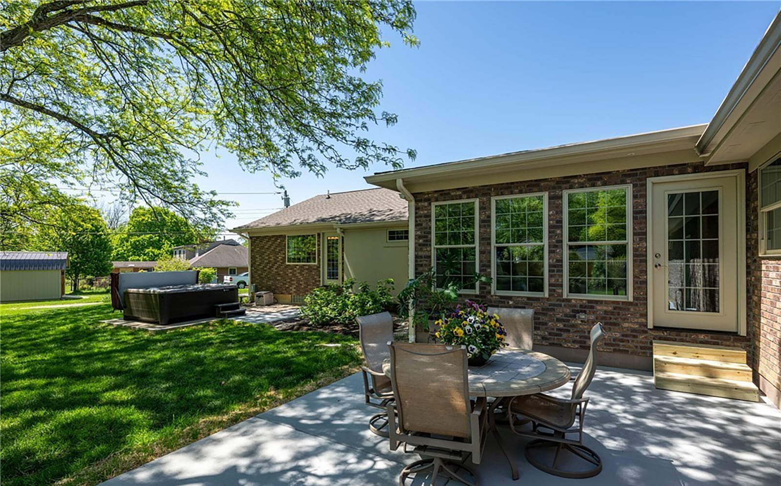 The rear of the home features a concrete patio and an area for a hot tub.
