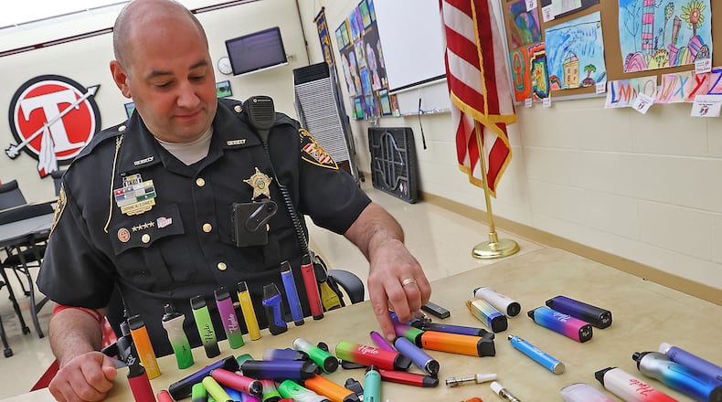 Clark County Sheriff's Deputy John Loney shows some of the recent vaping pens that have been confiscated at Tecumseh High School. Deputy Loney said this is the second batch of confiscated pens he's collected at the school. BILL LACKEY/STAFF