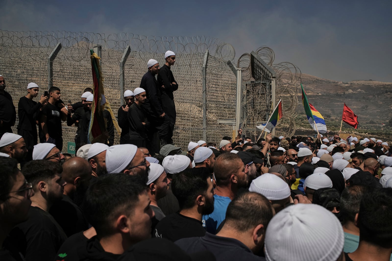 Druze from Syria and Israel protest on the Israeli-Syrian border, in Majdal Shams in the Israeli-controlled Golan Heights, Wednesday, July 16, 2025, amid the ongoing clashes between Syrian government forces and Druze armed groups in the southern Syrian city of Sweida. (AP Photo/Leo Correa)