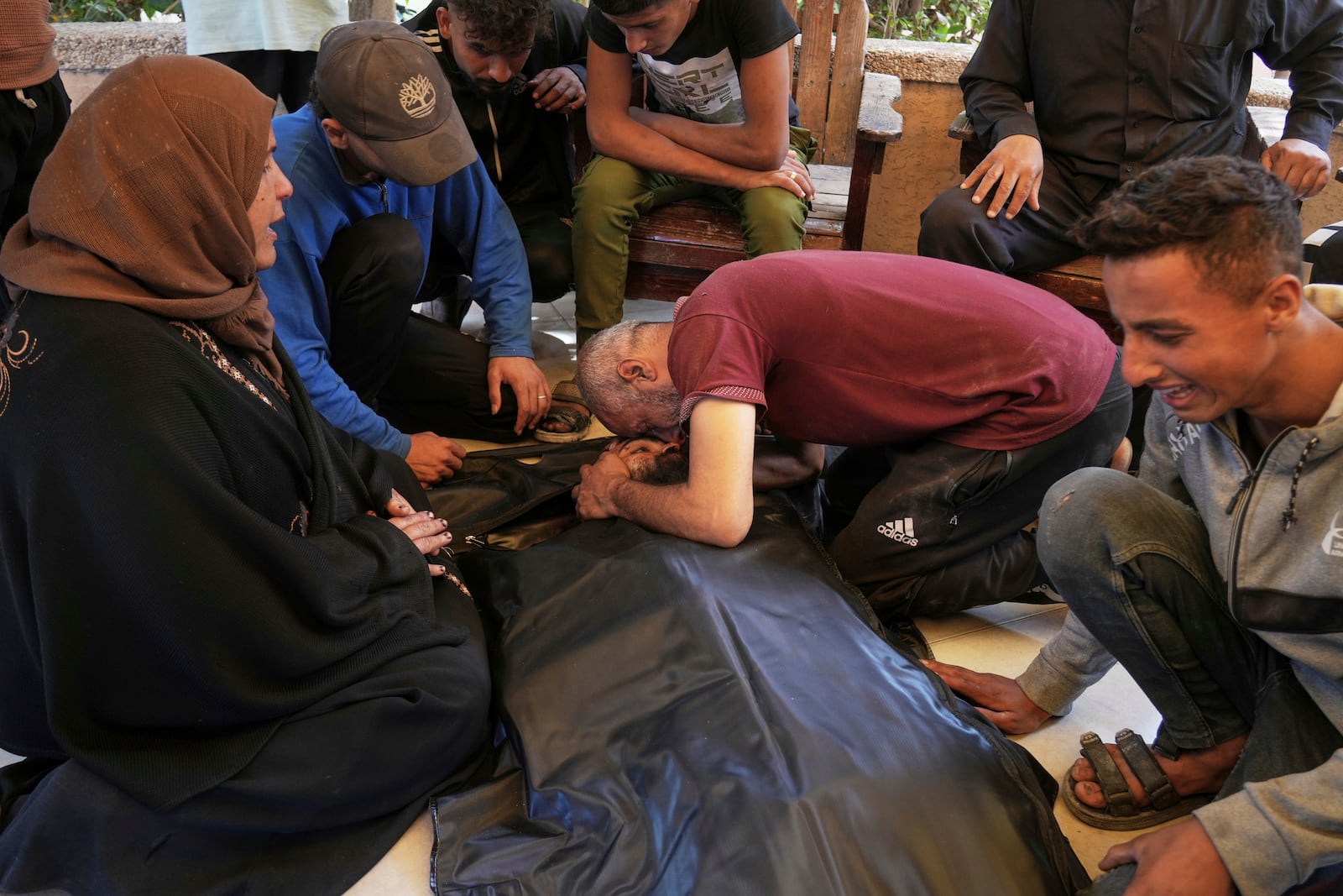 Relatives mourn over the body of Osama Abu Sahloul, who was killed when an Israeli army strike hit a house in Khan Younis, in the southern Gaza Strip, killing at least five members of the Abu Sahloul family, Thursday, May 1, 2025. (AP Photo/Abdel Kareem Hana)