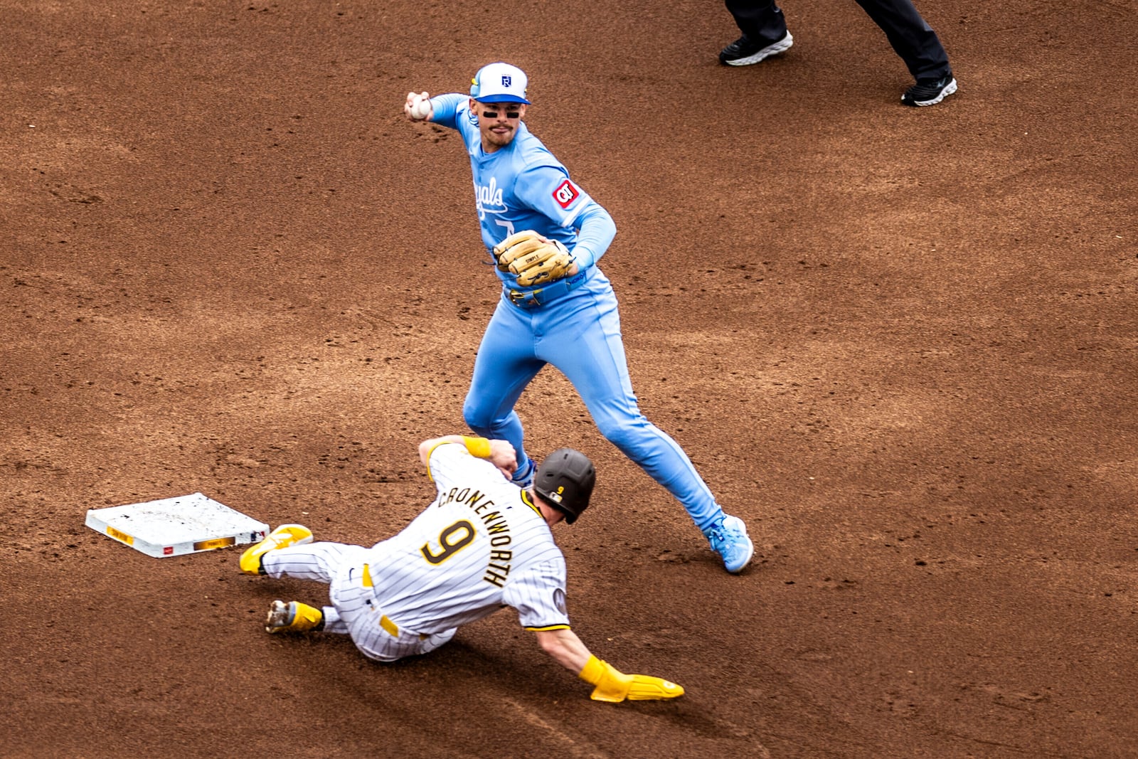 Kansas City Royals' Bobby Witt Jr. turns on a double play throwing to first as San Diego Padres' Jake Cronenworth slides out at second, in the second inning of a baseball game, Saturday, June 21, 2025, in San Diego. (AP Photo/Tony Ding)