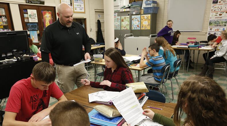 Teacher Matt Warrington goes over an assignment in his crowded 8th grade classroom at Reid School Friday. Bill Lackey/Staff