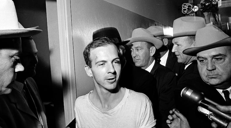 FILE — Surrounded by detectives, Lee Harvey Oswald talks to the media as he is led down a corridor of the Dallas police station, Nov. 23, 1963, for another round of questioning in connection with the assassination of U.S. President John F. Kennedy. The life insurance policy on the man who assassinated Kennedy paid out less than $900 to his mother, but the death claim she filed to get that sum has sold at auction for almost $80,000. The original Notice of Insurance Claim for Lee Harvey Oswald sold for $79,436 on Wednesday, April 13, 2022, Boston-based RR Auction said in a statement. (AP Photo/File)