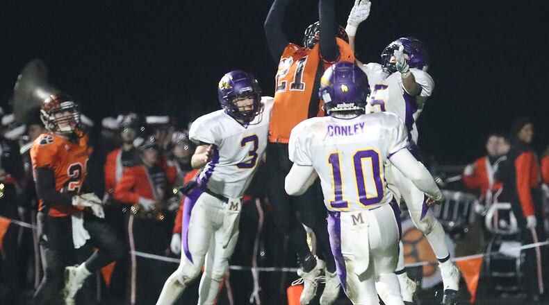 West Liberty-Salem’s Nick Burden makes a leaping touchdown catch under pressure from several Mechanicsburg defenders. BILL LACKEY/STAFF