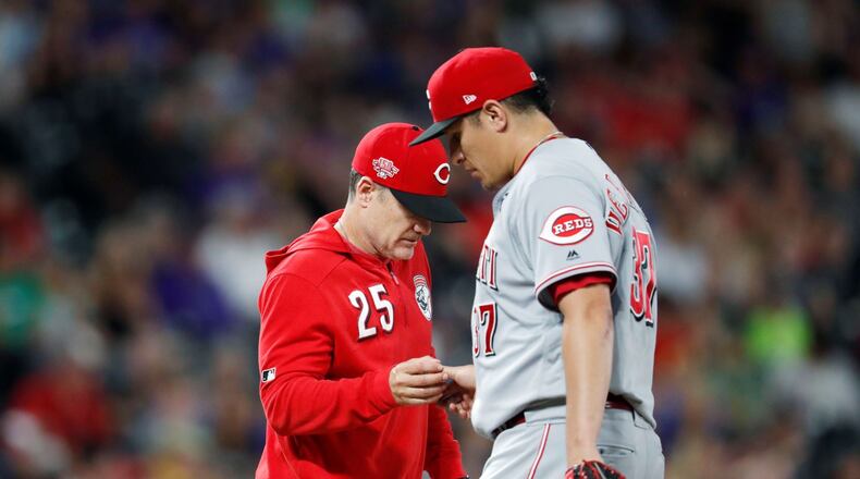 Cincinnati Reds manager David Bell, left, takes the ball from relief pitcher David Hernandez, who had given up a double to Colorado Rockies’ Ian Desmond during the eighth inning of a baseball game Friday, July 12, 2019, in Denver. (AP Photo/David Zalubowski)