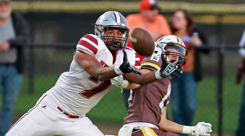 Urbana's Julian Davis catches a touchdown pass under pressure from Kenton Ridge's Bryndyn Parsons. BILL LACKEY/STAFF