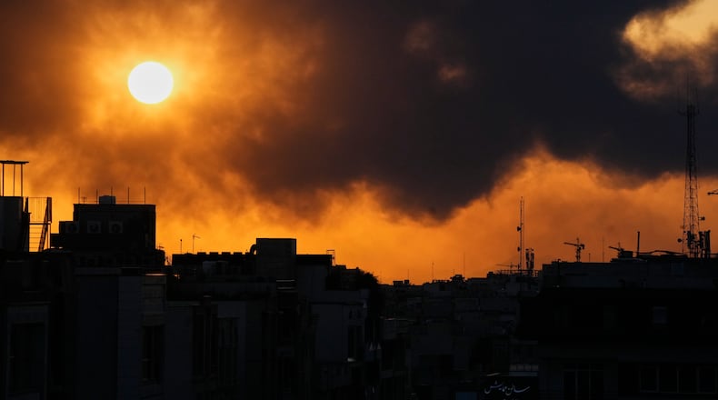 The sun sets behind a plume of smoke rising after a U.S.–Israeli military strike in Tehran, Iran, Tuesday, March 3, 2026. (AP Photo/Vahid Salemi)