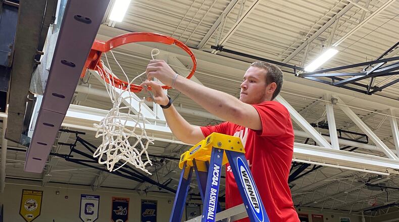 Wittenberg’s Connor Seipel cuts down the net after the cancellation of a game against Mount Union in the Sweet 16 on Thursday, March 12, 2020, in Alliance. Submitted photo