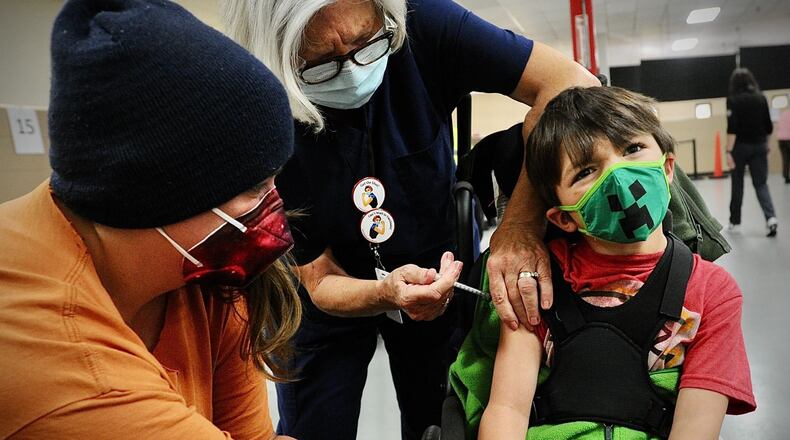 Ezio Hoos, age 5, makes a face while getting his COVID-19 shot in Springfield in November. Children younger than 5 are now eligible for the vaccine. MARSHALL GORBY\STAFF