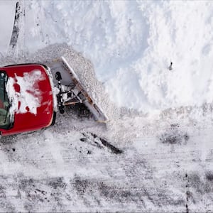 Aerial view of a snowplow clearing a snow-covered parking lot in Trenton, Ohio.