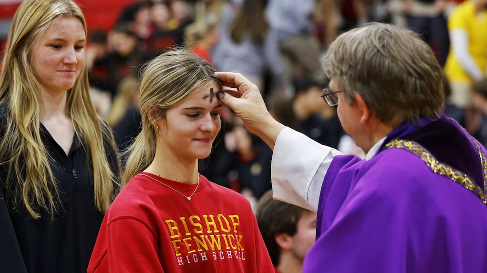 Madyson Schuh, left, receives ashes from Father Steve Pawelk with Glenmary Home Missioners during Bishop Fenwick High School's Ash Wednesday mass in the gymnasium Wednesday. Feb. 14, 2024. NICK GRAHAM/STAFF