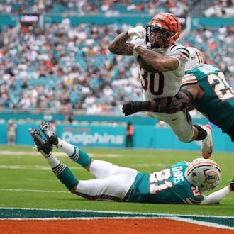 Cincinnati Bengals running back Chase Brown (30) breaks a tackle by Miami Dolphins linebacker Jordyn Brooks (20) for a touchdown during the second half of an NFL football game Sunday, Dec. 21, 2025, in Miami Gardens, Fla. (AP Photo/Lynne Sladky)