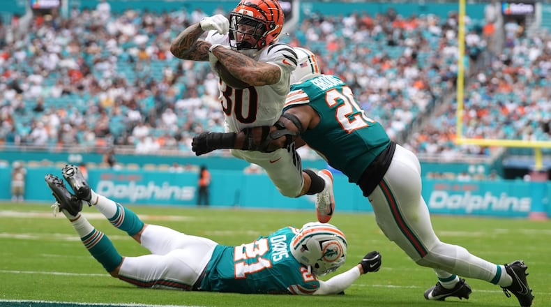 Cincinnati Bengals running back Chase Brown (30) breaks a tackle by Miami Dolphins linebacker Jordyn Brooks (20) for a touchdown during the second half of an NFL football game Sunday, Dec. 21, 2025, in Miami Gardens, Fla. (AP Photo/Lynne Sladky)