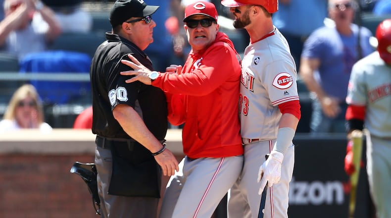 NEW YORK, NEW YORK - MAY 02:  David Bell #25 of the Cincinnati Reds get inbetween Jesse Winker #33 and umpire Marty Foster #60 after Jesse Winker was thrown out of the game for arguing a strike call in the eighth inning against the New York Mets at Citi Field on May 02, 2019 in New York City. (Photo by Mike Stobe/Getty Images)