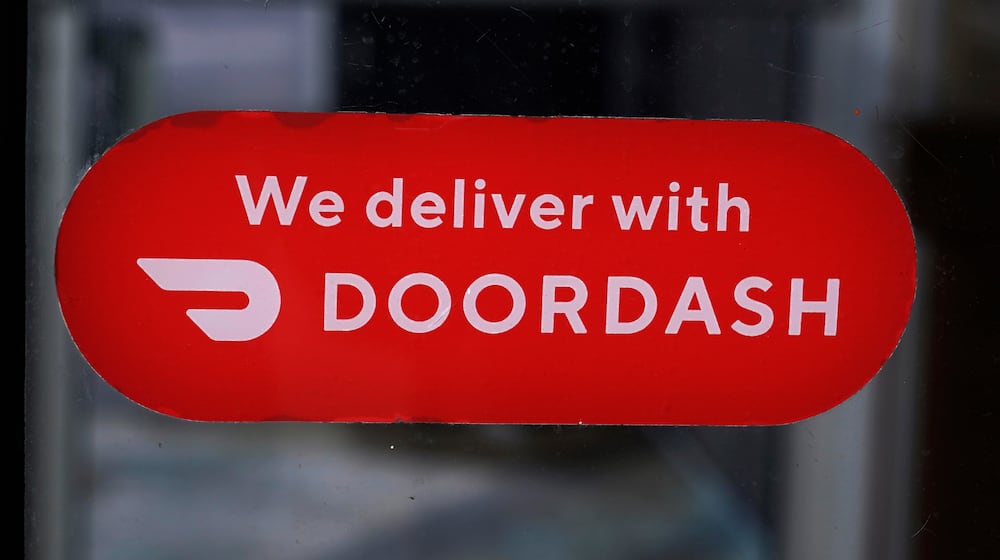FILE - A DoorDash sign is posted on the door of a Dunkin' Donuts franchise, Feb. 27, 2023, in Methuen, Mass. (AP Photo/Charles Krupa, File)