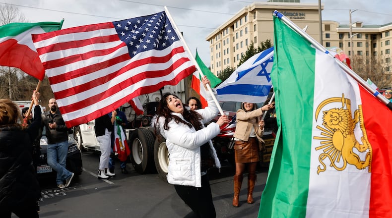 Karla Mohtashemi, center, celebrates as Voice of Iran hosts a car rally in Bellevue, Wash., on Saturday, Feb. 28, 2026, in response to the U.S. bombing of Iran. (Karen Ducey/The Seattle Times via AP)