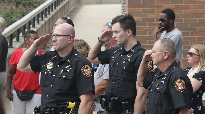Members of the Clark County Sheriff's department salute as the body of Deputy Matthew Yates passes by Monday. BILL LACKEY/STAFF