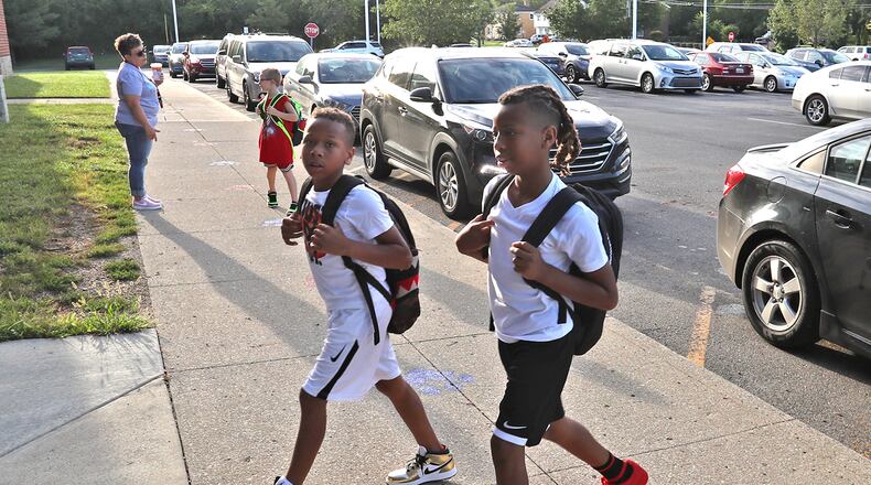 Students walk into Lagonda Elementary for the first day school Wednesday morning. BILL LACKEY/STAFF