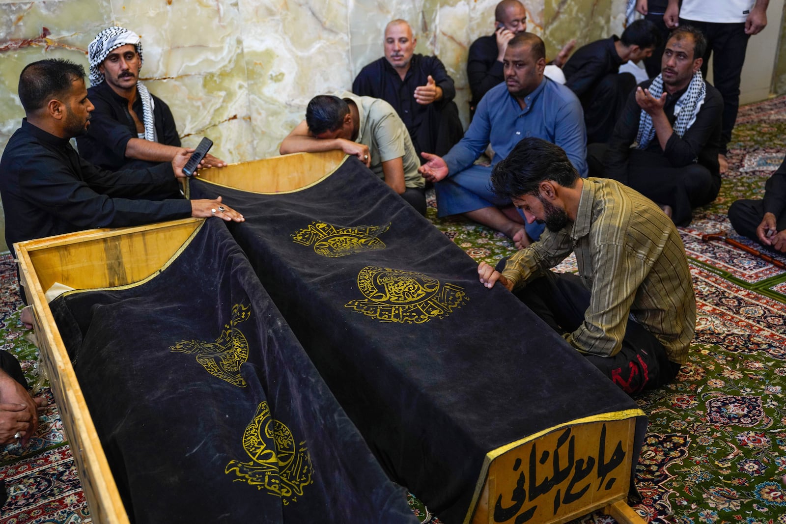 Mourners attend the funeral of victims who died in a fire at a shopping center in Kut, at the shrine of Imam Ali in Najaf, Iraq, Thursday, July 17, 2025. (AP Photo/Anmar Khalil)