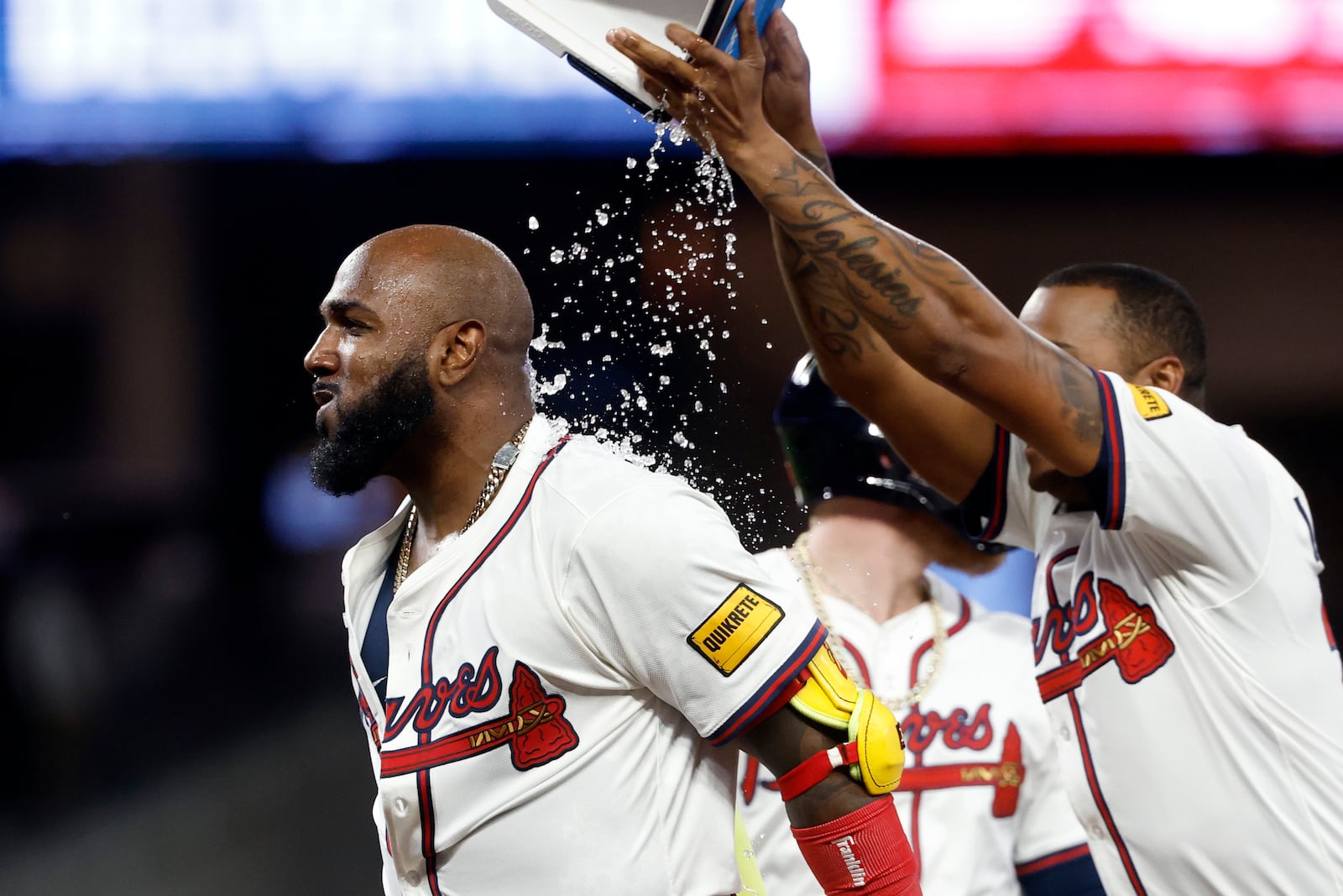 Atlanta Braves designated hitter Marcell Ozuna (left) is doused with water by Raisel Iglesias (right) after hitting a walk off RBI during the10th inning of a baseball game to beat the Cincinnati Reds, Tuesday, May 6, 2025, in Atlanta. (AP Photo/Butch Dill)
