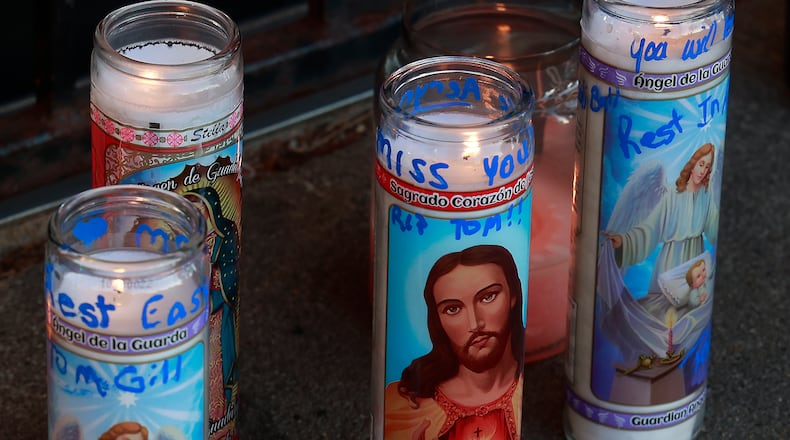 Family, friends and community members filled the parking lot of Gill's Quality Meat Market Monday, Jan. 9, 2023 during a candle light vigil for Thomas Gill, who was shot and killed while driving his SUV in Springfield. BILL LACKEY/STAFF