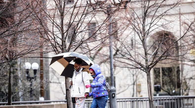 Laketrica Graves and her daughter, Dareyall share an umbrella walking to CVS across Courthouse Square on a rainy Tuesday afternoon March 22, 2022, JIM NOELKER/STAFF