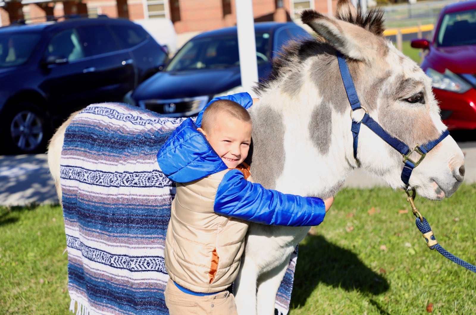 First grade student Logan Madden hugs Biblioburro the donkey during a recent visit Biblioburro had at Kenwood Elementary School as part of a language arts lesson. They were able to ask questions, pet and hug the donkey, and get a new book to take home. CONTRIBUTED