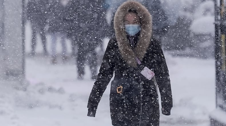 A pedestrian walks along 42nd Street near Bryant Park during a snow storm, Monday, Feb. 23, 2026, in New York. (AP Photo/Seth Wenig)
