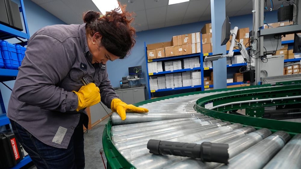 Maintenance technician Liz Cardenas replaces a conveyor belt roller at a training area in a Walmart distribution center Thursday, Sept. 25, 2025, in Bentonville, Ark. (AP Photo/Charlie Riedel)
